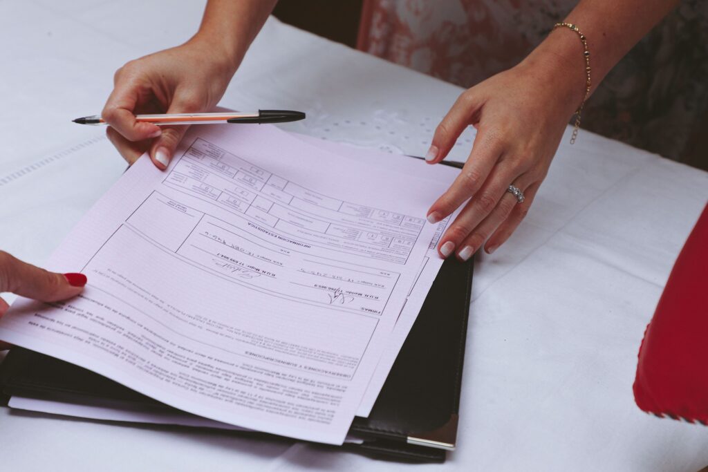 Persona firmando un documento, referencia a la renuncia a una herencia ante notario